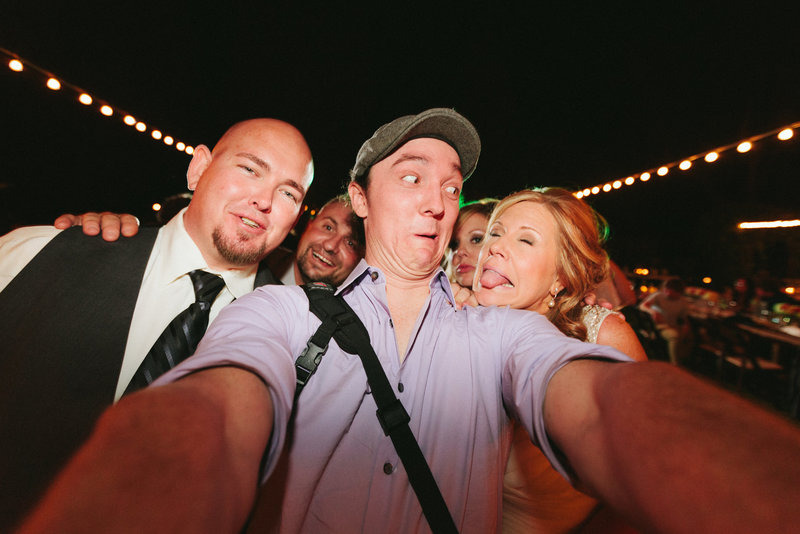 Goofy wedding photographer selfie with bride and groom