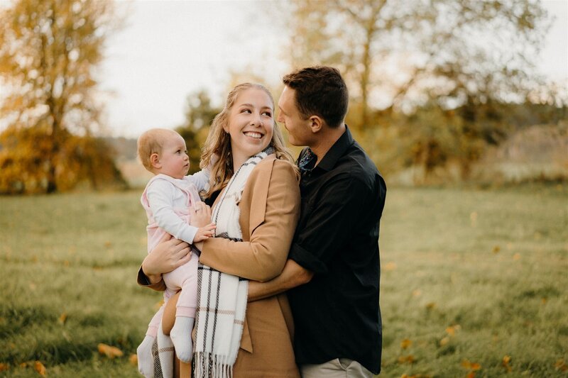 A family stand  looking at each other at sunset in autumn.
