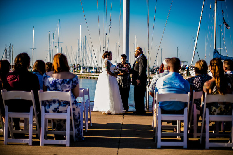 Couple exchanges vows in front of the flagpole at the Erie Yacht Club