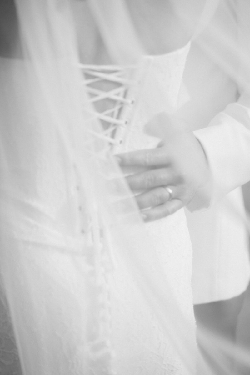 Editorial styled photo of groom holding the back of his bride