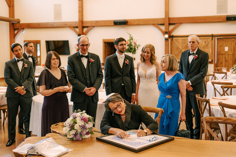 bride and groom with other guests inside the barn at barnwood events in madison, winconsin.