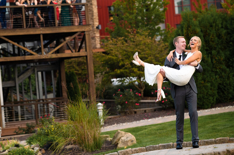 Groom, holding his bride outside of the wedding reception at Bear Creek Mountain resort