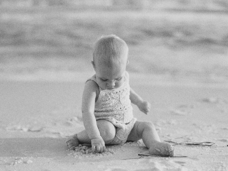 A newborn playing in the sand on the beach in Seaside, Florida.