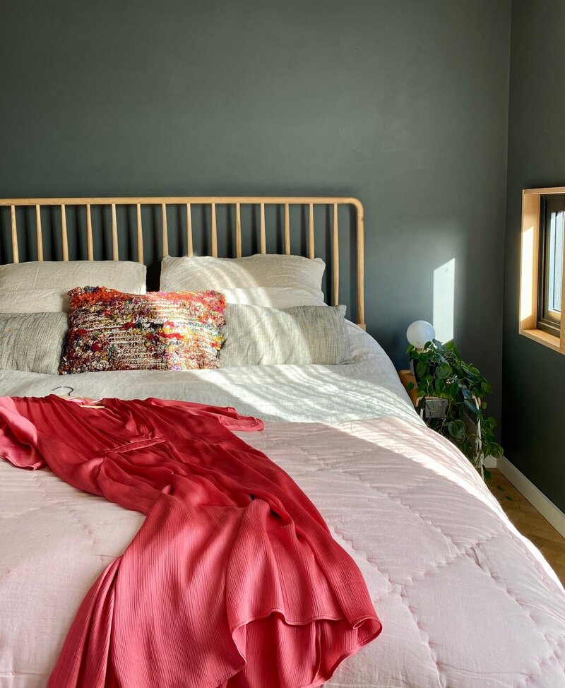 Wood headboard and linen sheets in bedroom interior