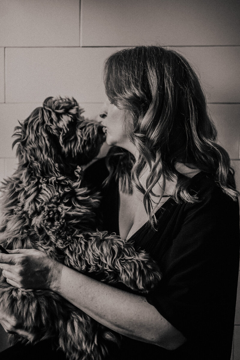 Woman kissing her Australian Labradoodle dog