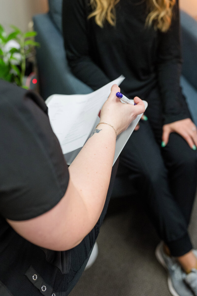 Tara filling out paperwork as she intakes a client