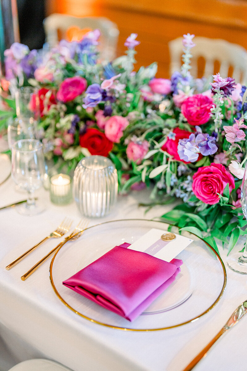 Colorful wedding tablescape with pink napkins and vibrant florals at Yacht Club reception in San Francisco CA