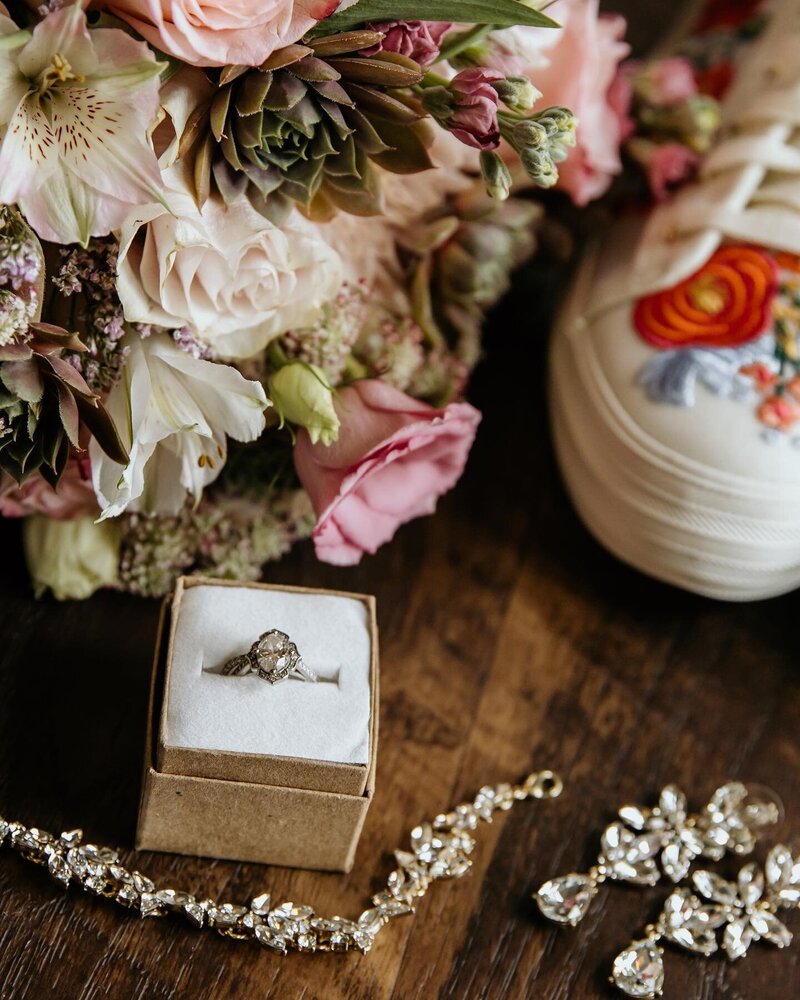 wedding ring next to flowers and a shoe