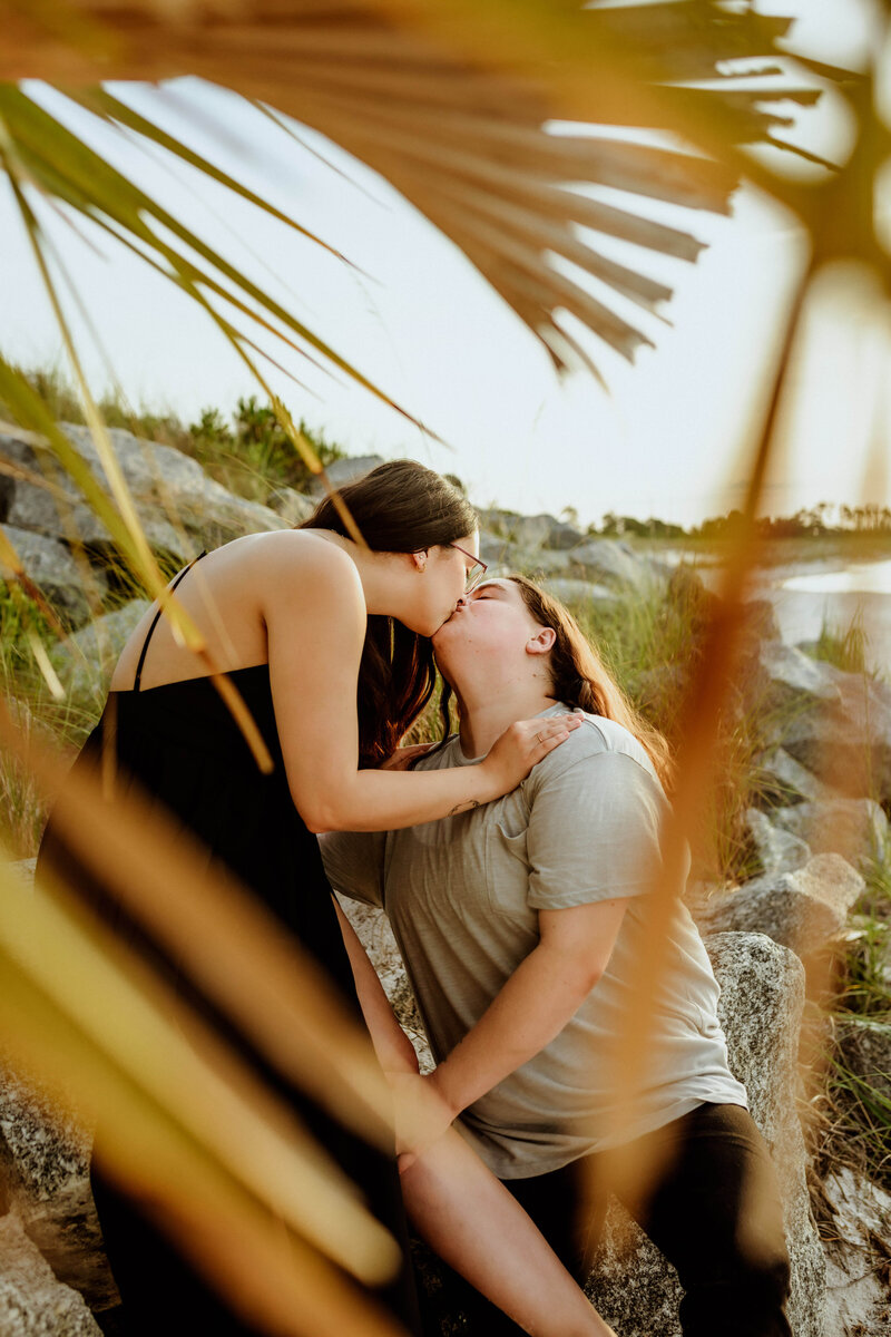young same sex couple kisses & embraces on beach to celebrate engagement session by Brittney Stanley of Be Seen Photos