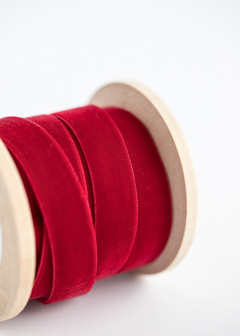 Red velvet ribbon on a spool — a holiday detail often featured in pictures with Santa Tulsa for a timeless look.