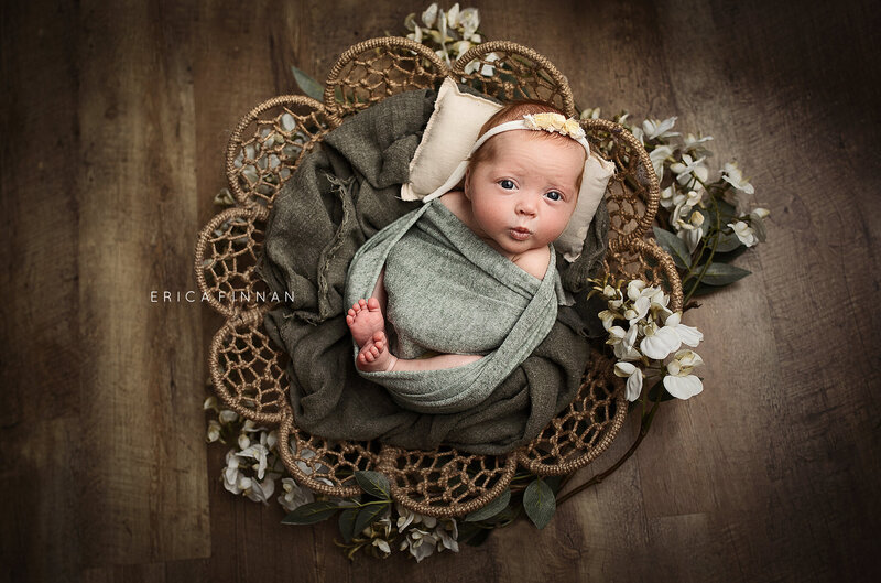 newborn baby wrapped in green wrap