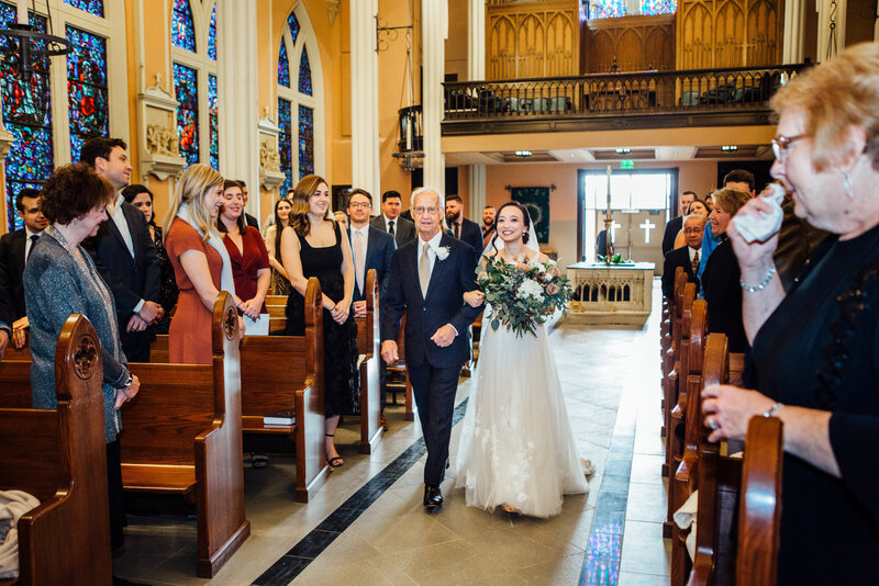 Father walking bride down isle during ceremony at St. Johns