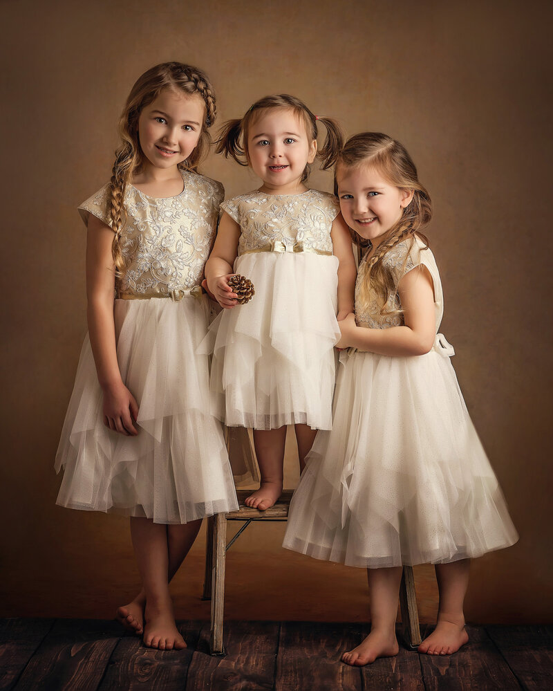 3 sisters in ivory dresses smile in fine art portrait session