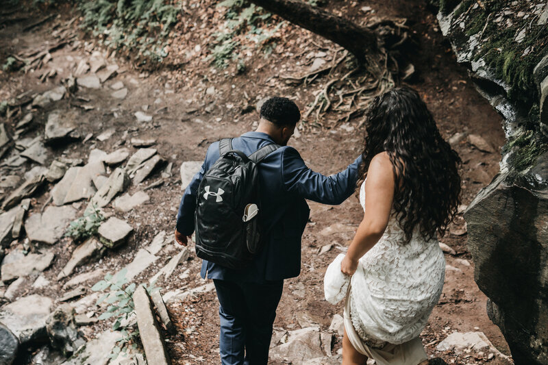 AJ guides his bride as they make their way down the path towards the waterfalls.