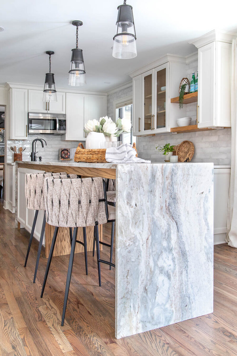 Beautiful kitchen designed by Midlands SC interior designer Haven + Harbor featuring wood flooring and a striking marble waterfall island