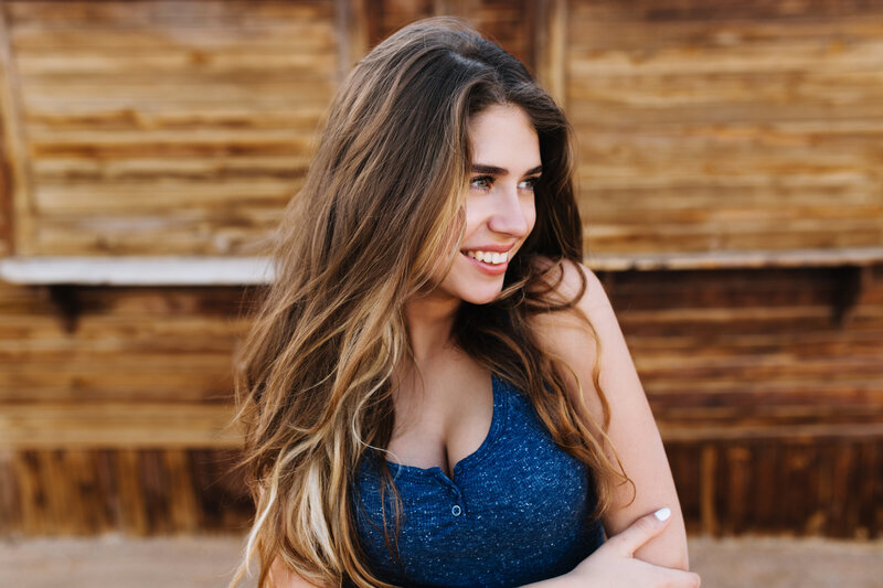 close-up-portrait-fascinating-long-haired-girl-with-lovely-face-expression-looking-away-dreamy-curly-young-woman-blue-knitted-tank-top-beautiful-smiling