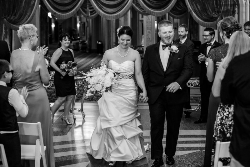 Bride and groom walk down the aisle at the end of their Warner Theatre wedding