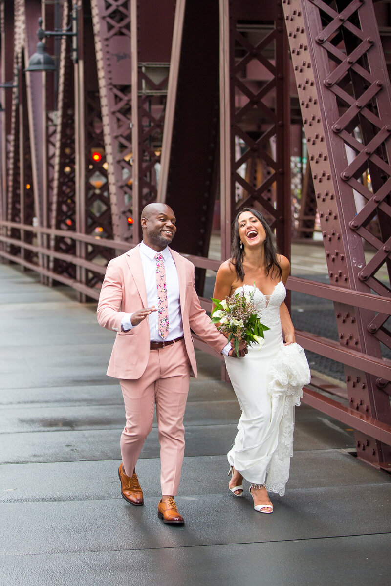 Bride and groom laughing at a Chicago river bridge.
