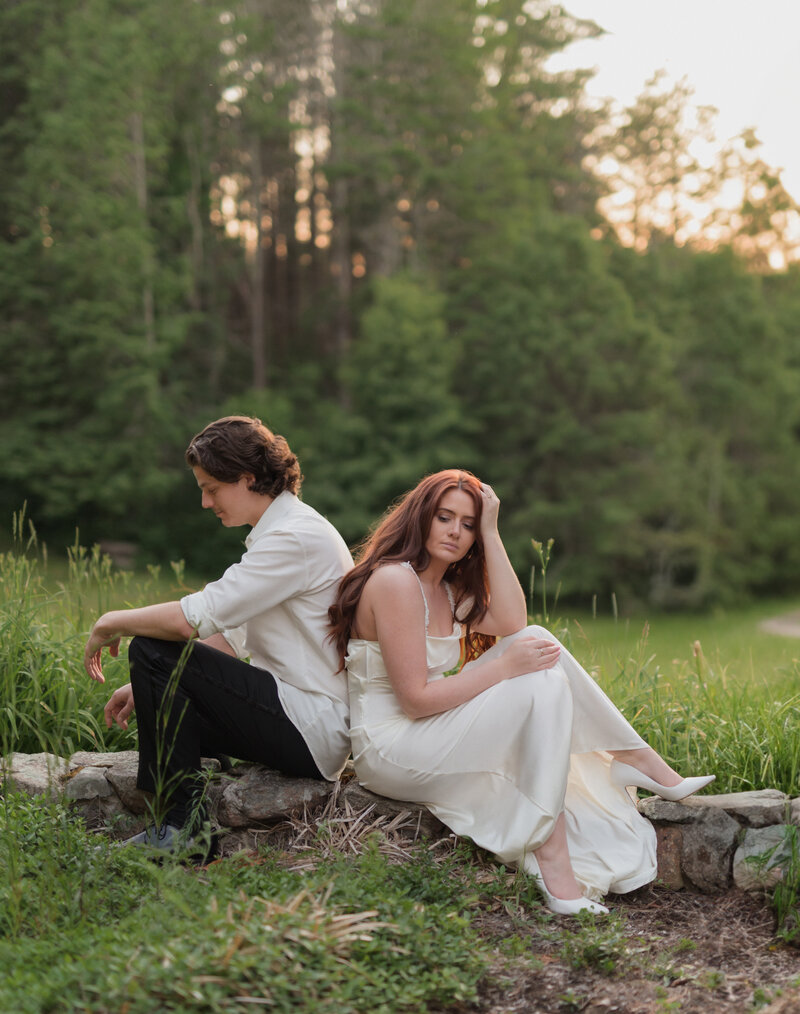summer engagement session outdoors surrounded by green. women wearing formal white dress with auburn hair