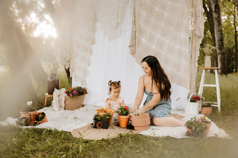 mom and kid sitting on blanket in grass