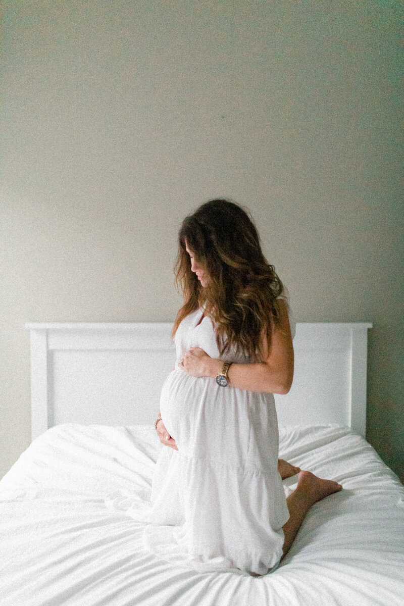 pregnant mother on bed at home by Orlando newborn photographer