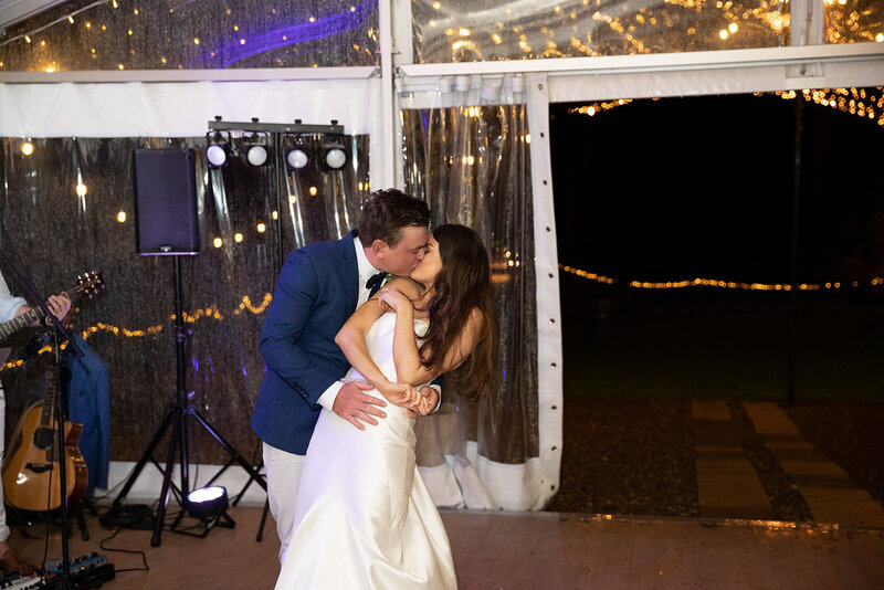 Newly-weds kissing and dancing at wedding reception