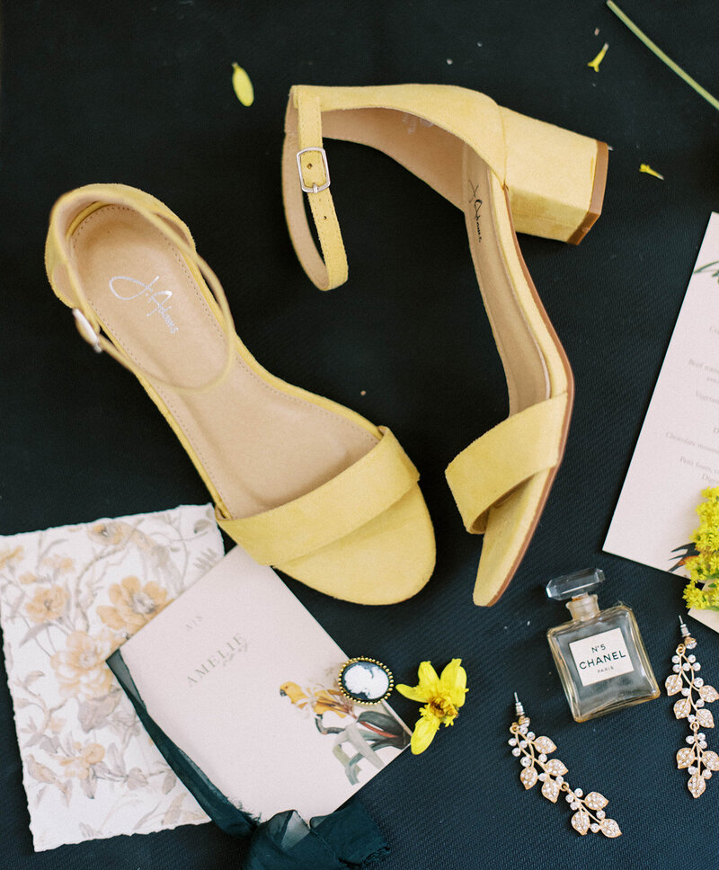 black background with bright yellow heels and other wedding details