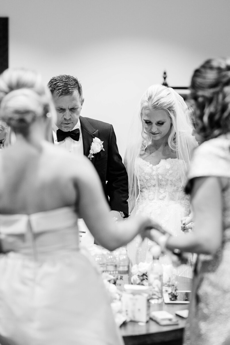 bride and family praying before ceremony by knoxville wedding photographer