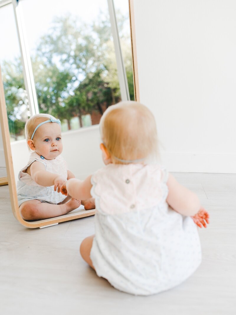 baby looks in mirror