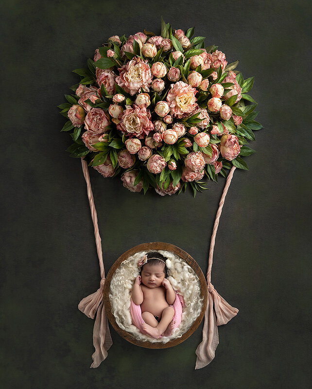 Newborn girl in floral hot air balloon.