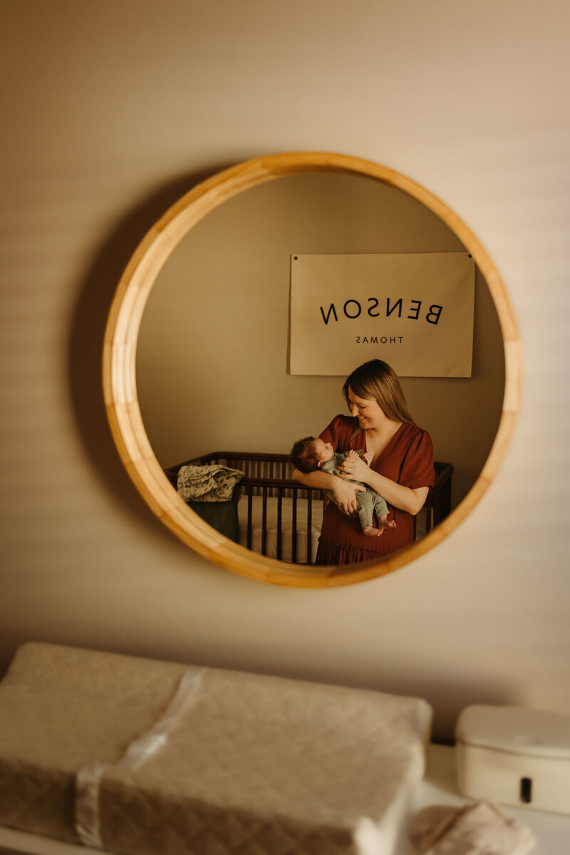 mom holding baby in nursery