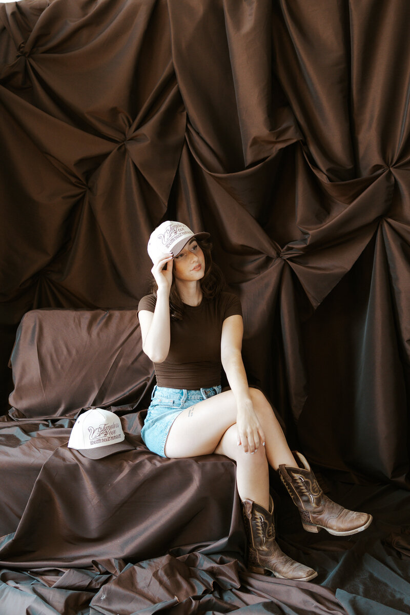 wearing the hat on a brown background for engagement photos