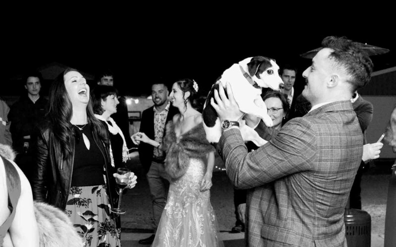 Wedding dance party with a man carrying a dog
