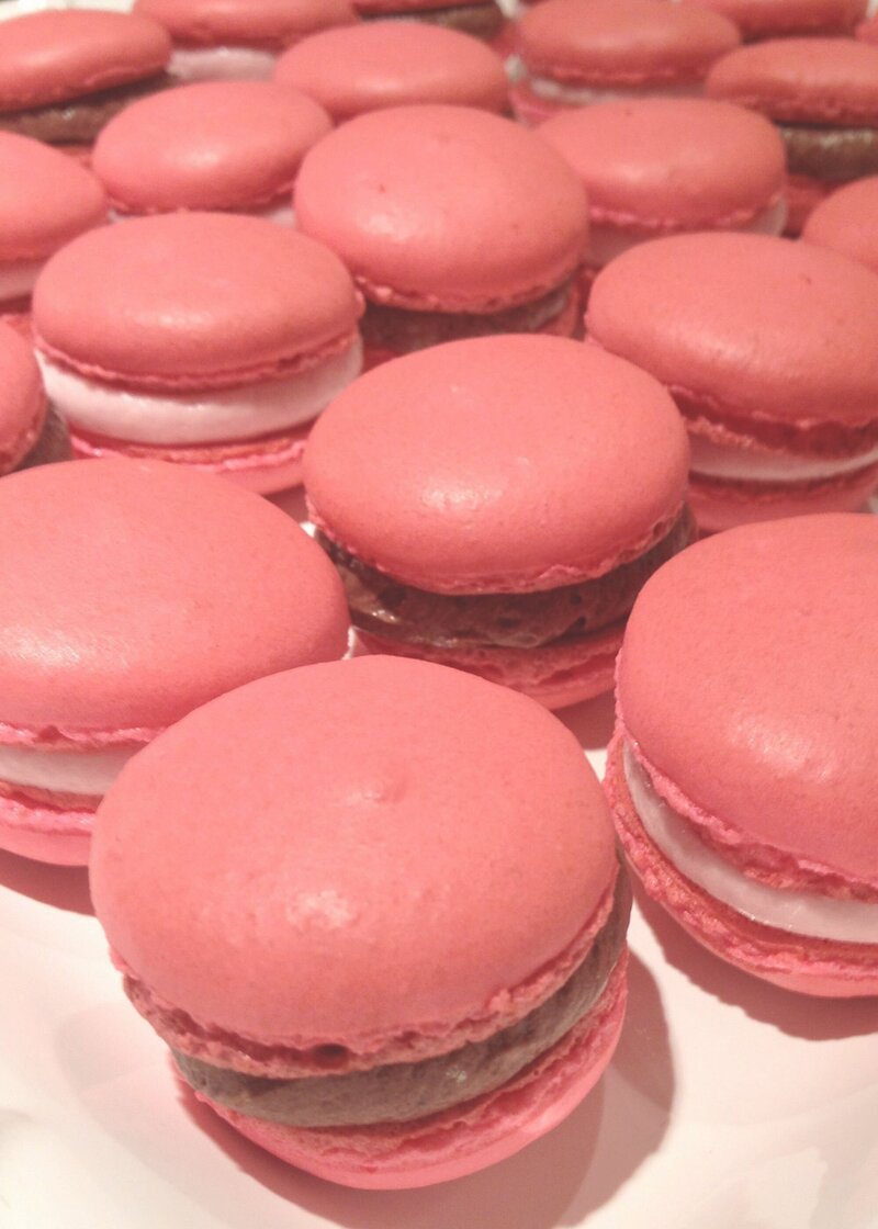 Rose-colored French macarons with script text overlay 'chocolate & rose, the perfect combo.