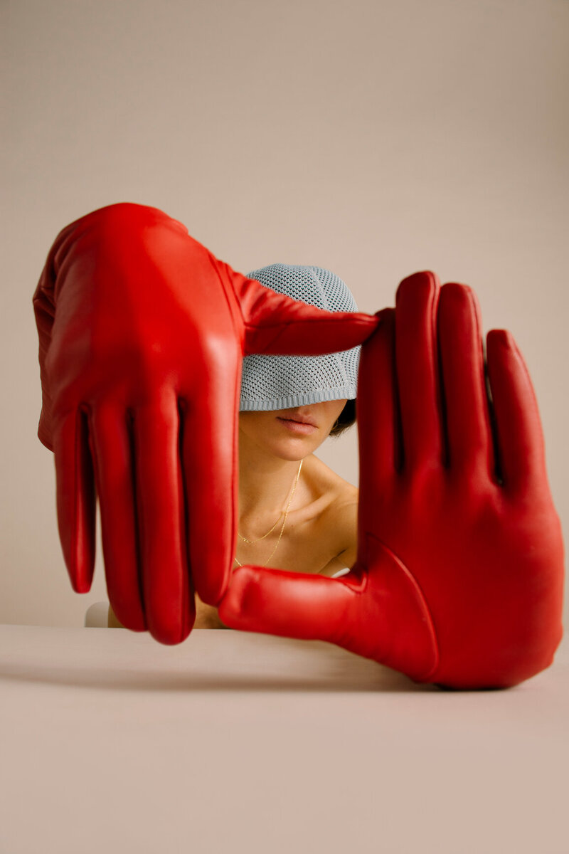 Model wearing red gloves and blue hat
