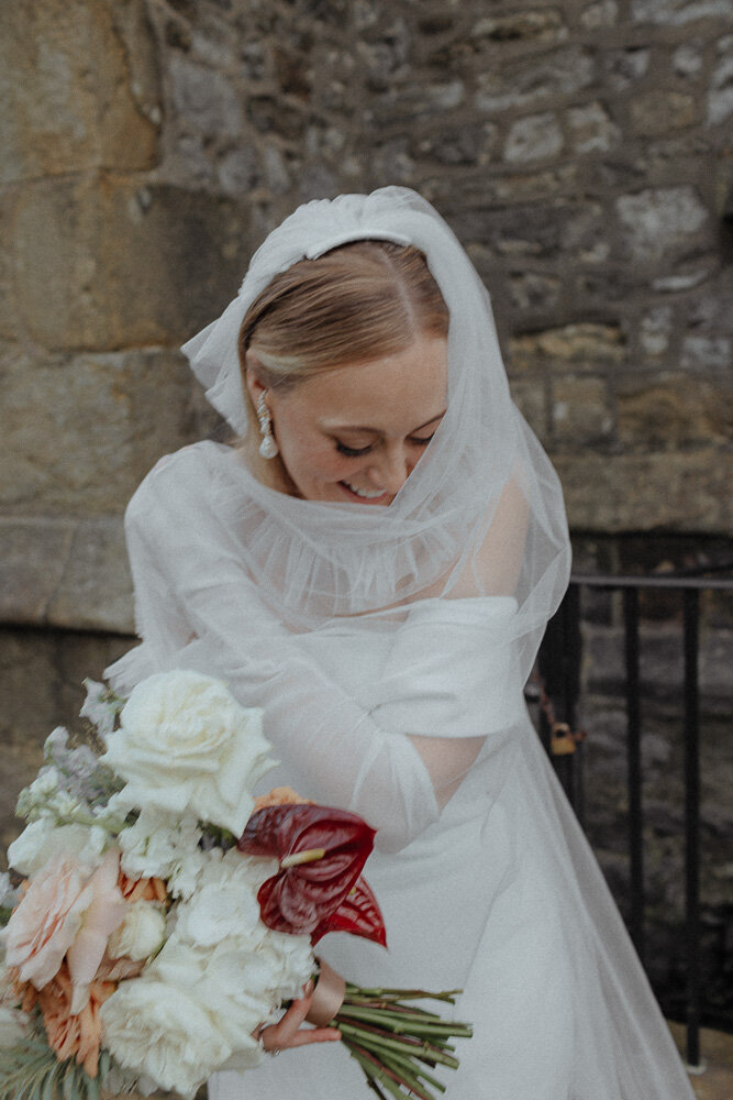 bride in wedding dress holding her veil at holmes mill wedding clitheroe