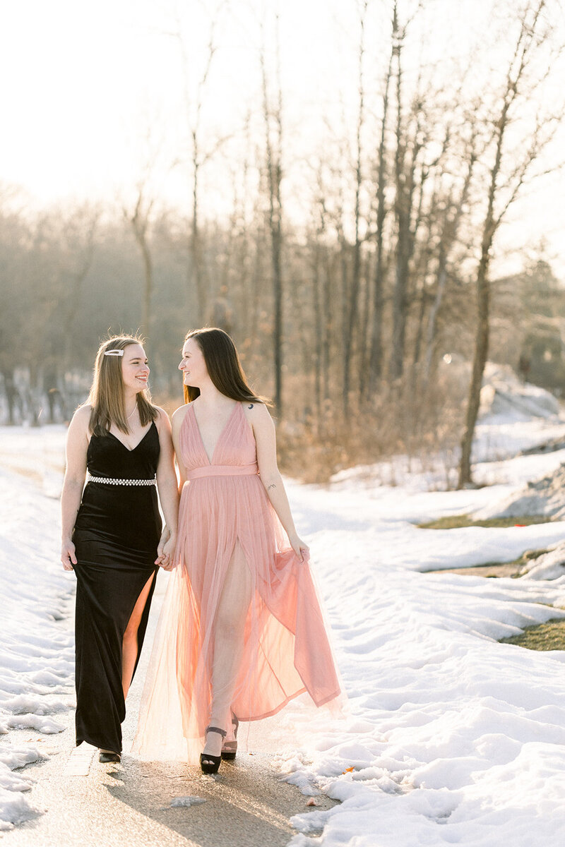 two brides holding hands and walking in their dresses
