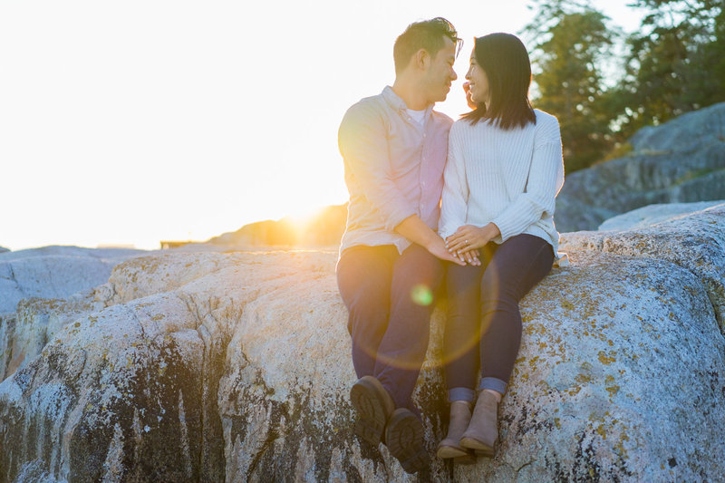 Couple sitting on a rock for their Whytecliff Park engagement session