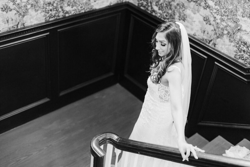 Black and white portrait of woman walking down staircase at luxury dallas wedding. By white orchid photography