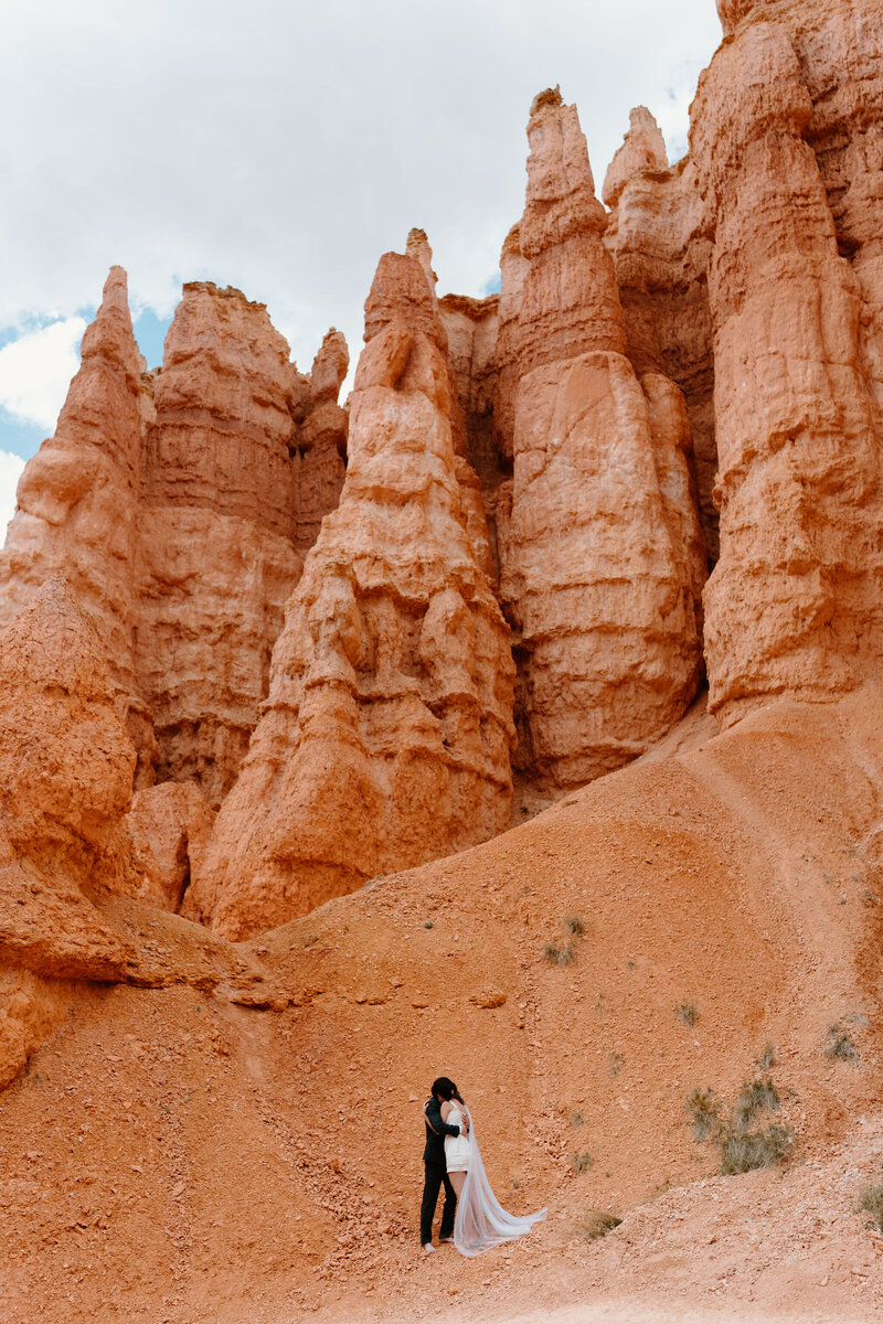 Bride and Groom (both in hiking boots) embracing after exchanging vows in their Utah Elopement