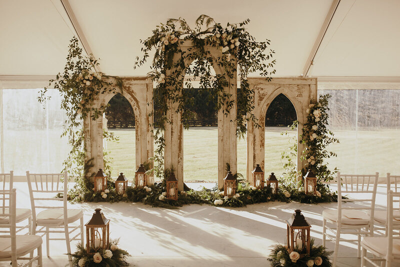 Wedding ceremony altar made from old Church windows covered in greenery.