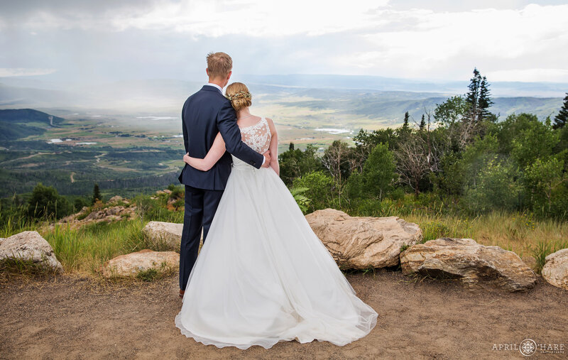 Bride leans her head on groom's shoulder as they look out at the views of Yampa Valley at the Vista Overlook in Steamboat Springs Colorado