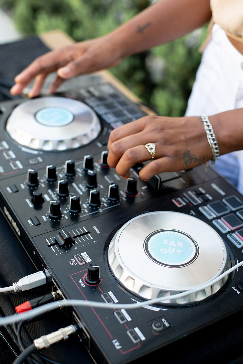 DJ hands hover over a set of turn tables