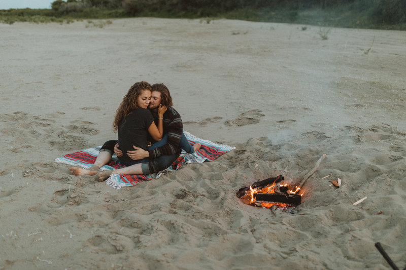 couple eating smores on the beach