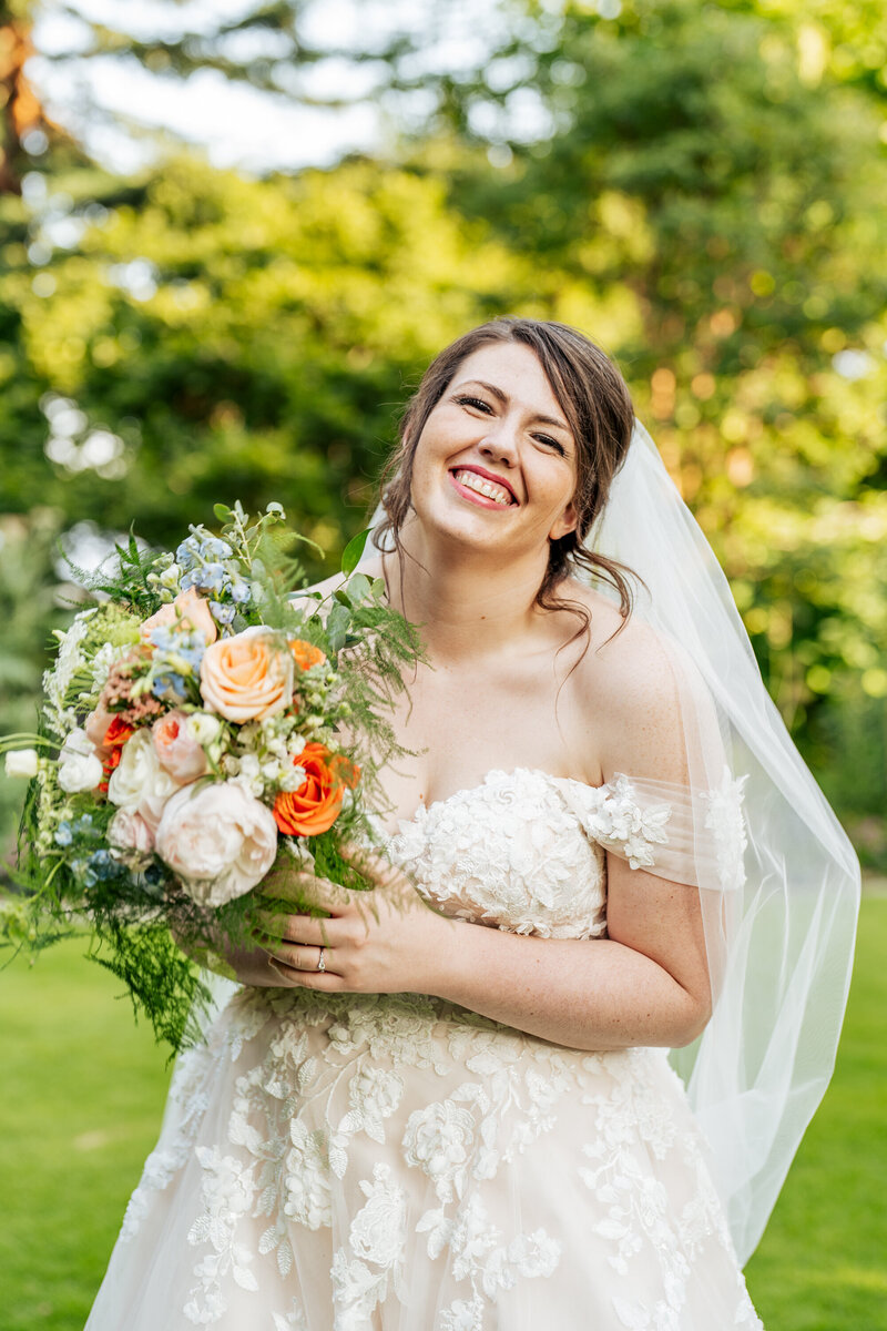 bride smiling with bouquet at Fred Fletcher park near Downtown Raleigh, NC