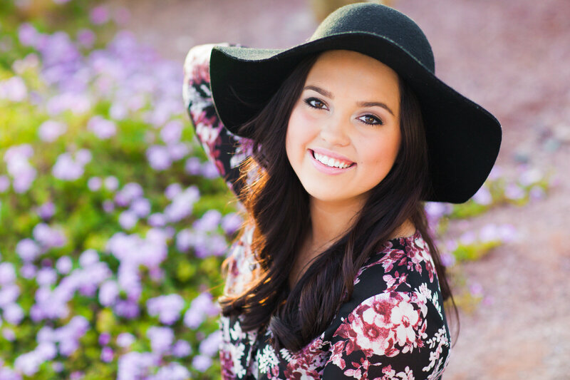 high school senior girl posing for Phoenix senior photographer with hat
