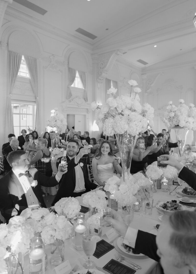 The bride and groom sharing a toast with their friends and family during the speeches on their wedding day.