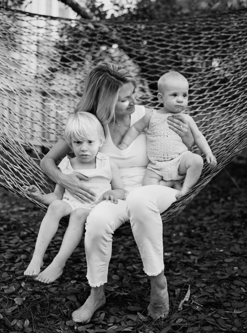 Two boys with their mom posing for a picture while on a hammock in Seaside, Florida.
