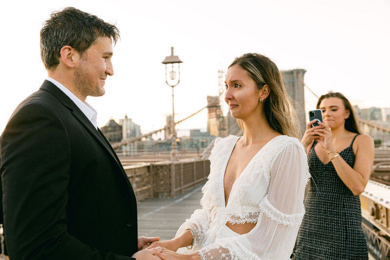 A couplemarry at sunrise on the Brooklyn Bridge.