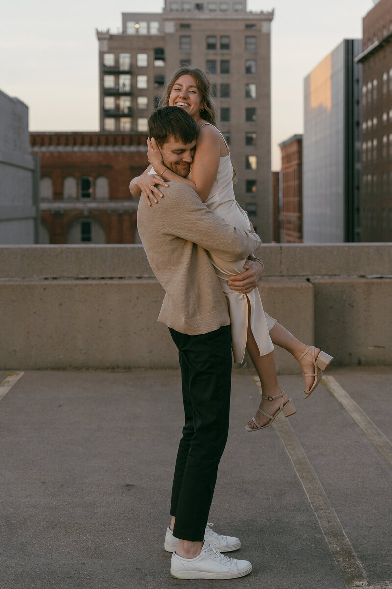 Couple embracing with city skyline in the background in an urban wedding photoshoot.